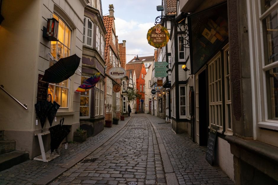 A picturesque cobblestone street in Bremen, Germany's historic old town, captured at dusk.